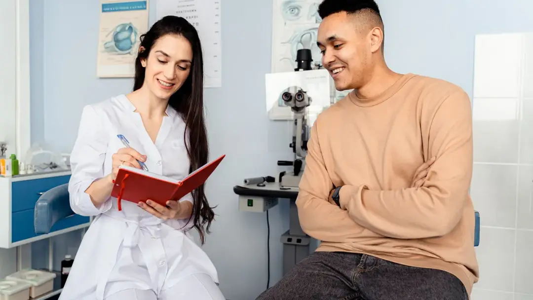 Médica conversando con un paciente durante una consulta en un consultorio
